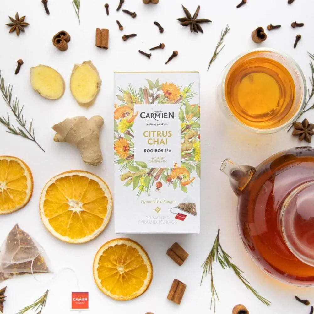 Citrus Chai Rooibos tea with fresh orange slices, ginger, and spices on a white background, perfect for tea lovers and e-commerce shoppers.