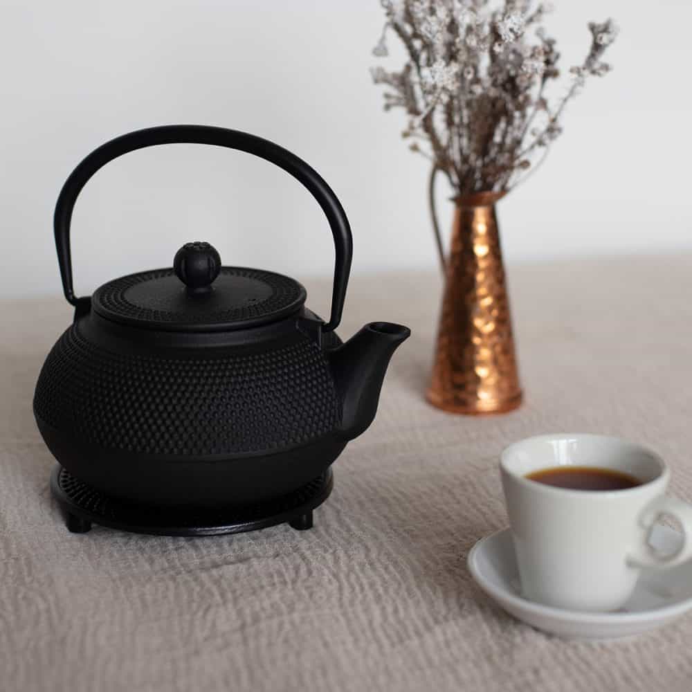 Traditional black cast iron teapot with a textured surface, 800ml capacity, perfect for brewing and serving tea.