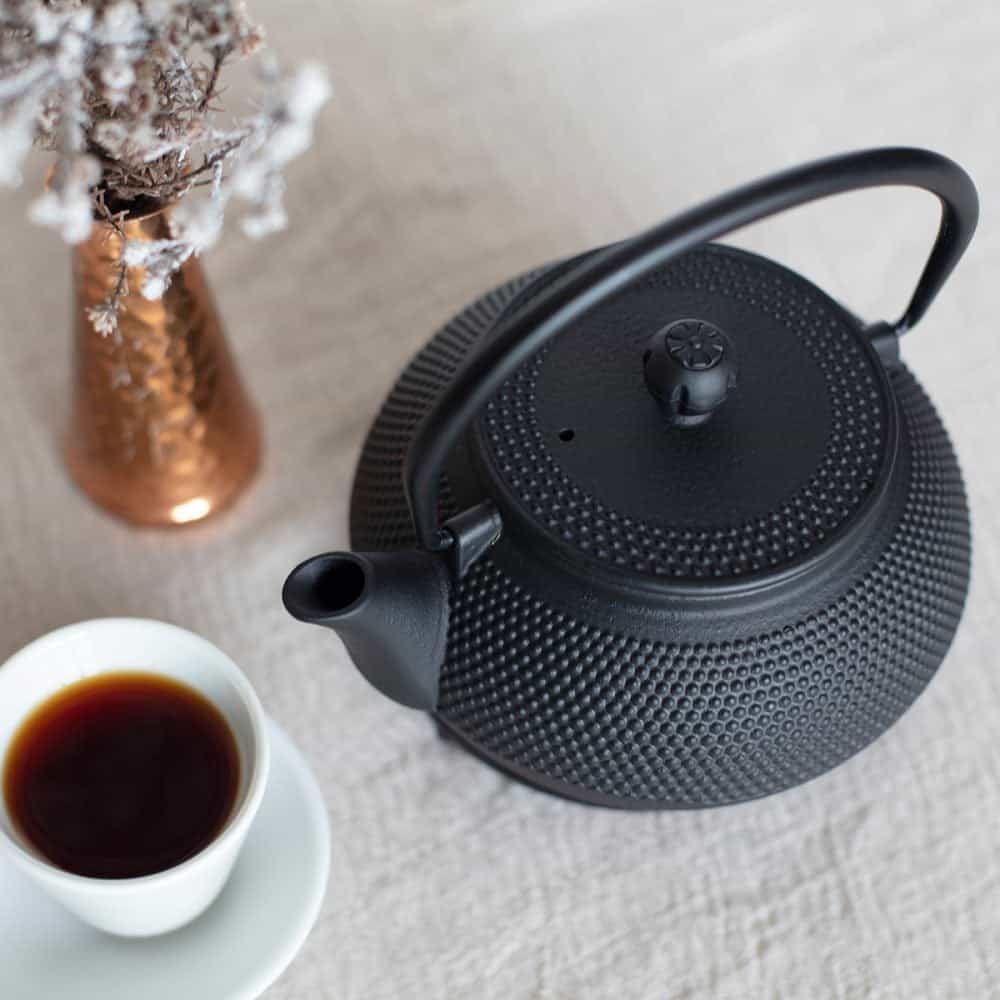 Elegant black cast iron teapot for brewing tea, featuring a durable design and 800ml capacity, perfect for tea lovers.