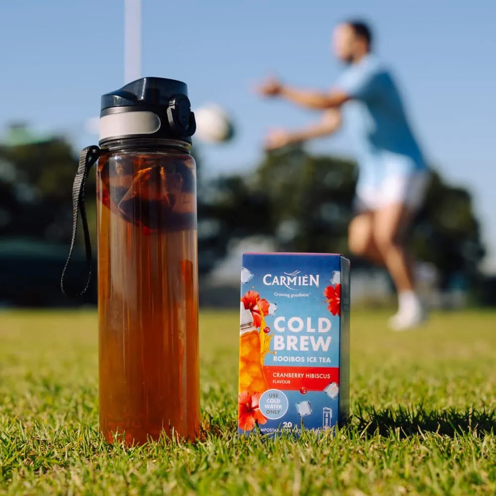 Carmién Cranberry Hibiscus Cold Brew Rooibos Tea in a box with a water bottle in the background, ideal for refreshing e-commerce sales.