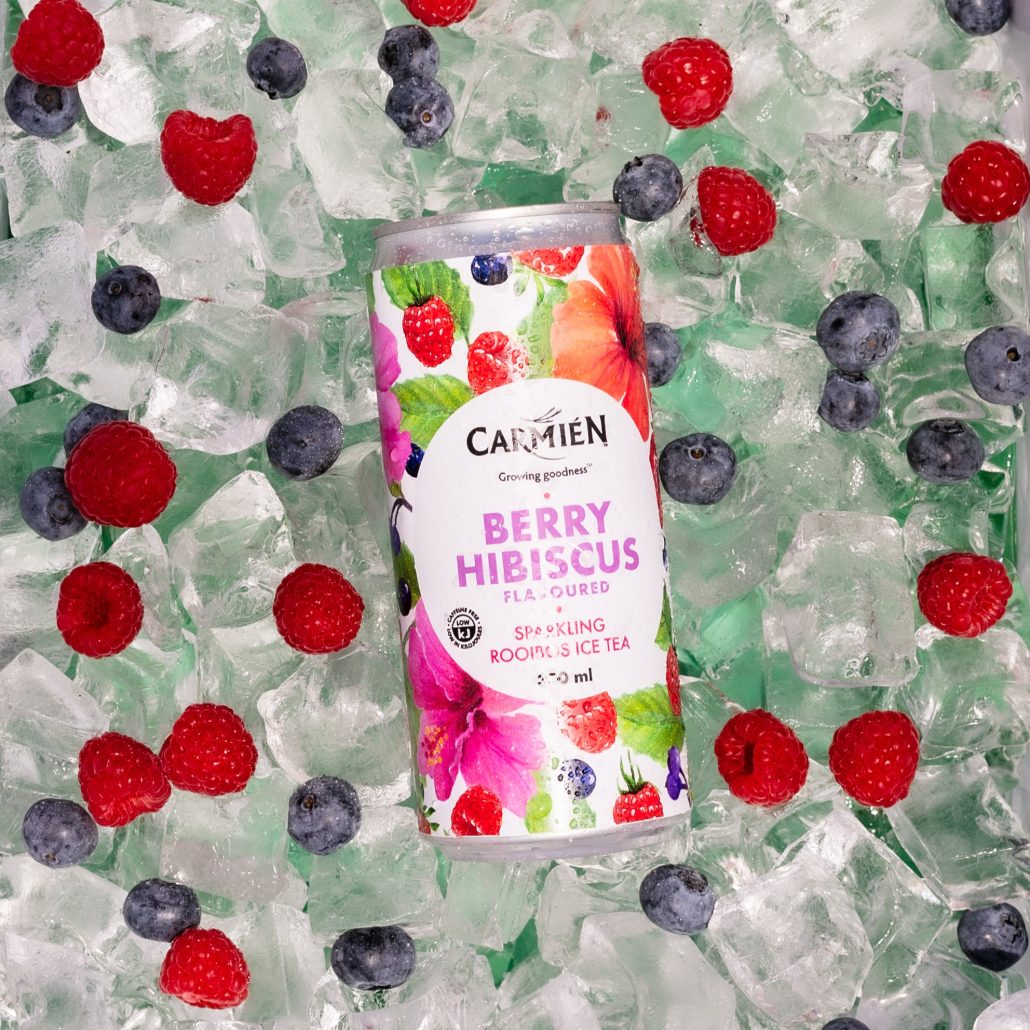 Refreshing berry hibiscus flavored Rooibos ice tea can with vibrant, fruity packaging surrounded by ice and fresh berries for a cool, antioxidant-rich beverage experience.
