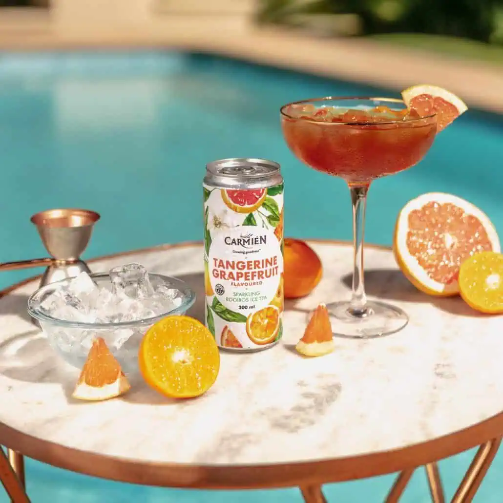 Refreshing citrus-flavored Carmién tea with tangerine and grapefruit, served over ice by the poolside for perfect summer relaxation.
