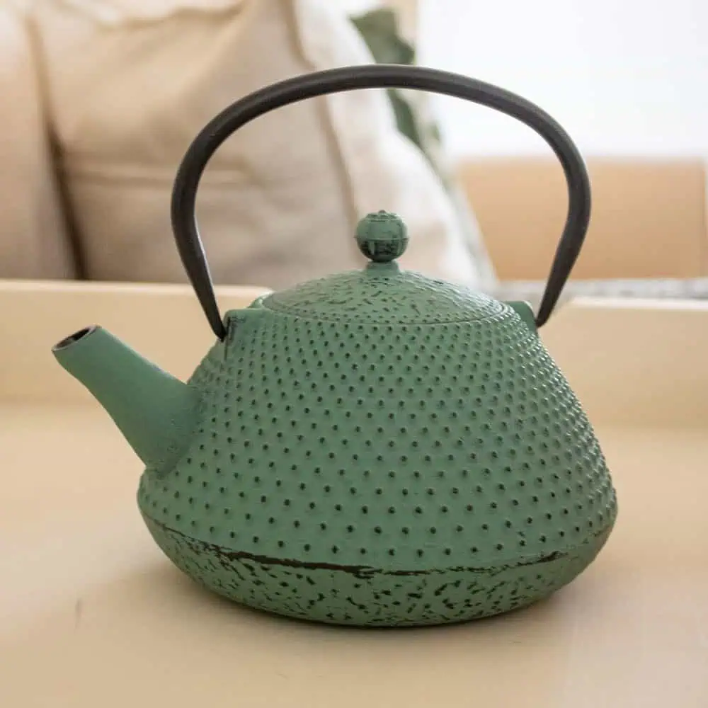 Sage green cast iron teapot with a pear shape, perfect for brewing and serving Carmién Tea. Durable, heat-retentive, and stylish, ideal for tea lovers seeking quality and tradition.