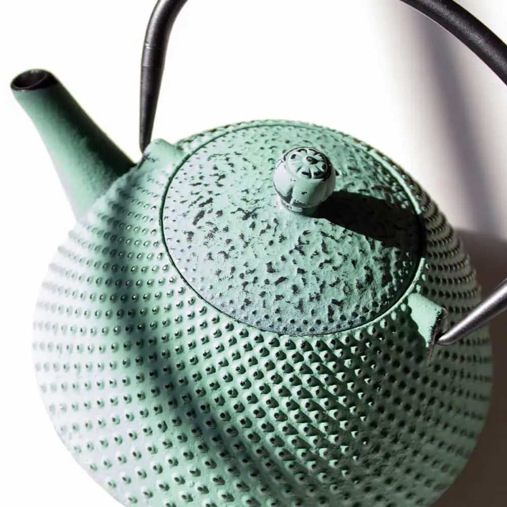Elegant sage green cast iron teapot with a pear shape, perfect for brewing and serving tea. Durable and stylish, ideal for tea lovers seeking quality and aesthetic appeal.