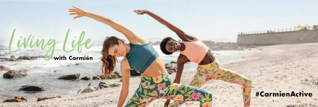 Brightly dressed women practicing yoga on the beach, promoting wellness and vitality with Carmién Tea for a healthy, active lifestyle in South Africa.