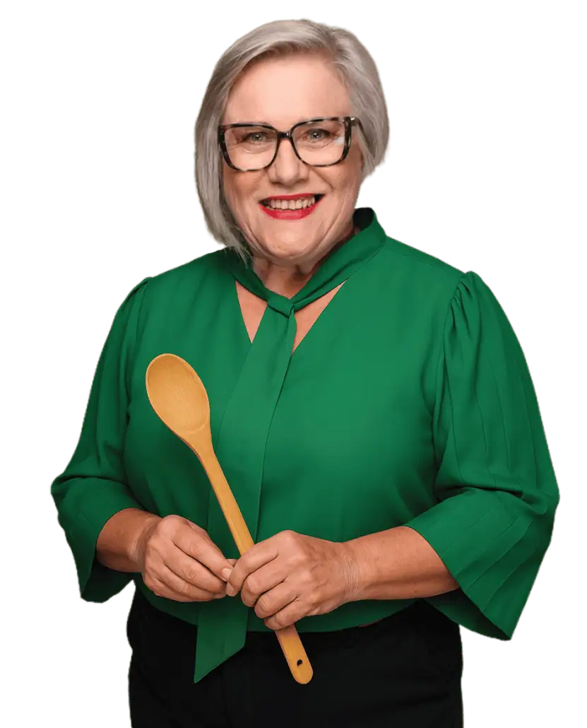 Rooibos tea expert Carmen Niehaus holding a wooden spoon, showcasing the versatility of Carmién Rooibos in cooking and tea preparation.