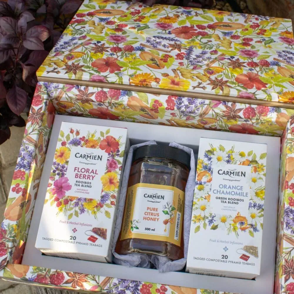 Elegant gift box featuring Carmién Pyramid Teas with Orange Chamomile and Floral Berry flavors, complemented by pure citrus honey for a delightful tea experience.