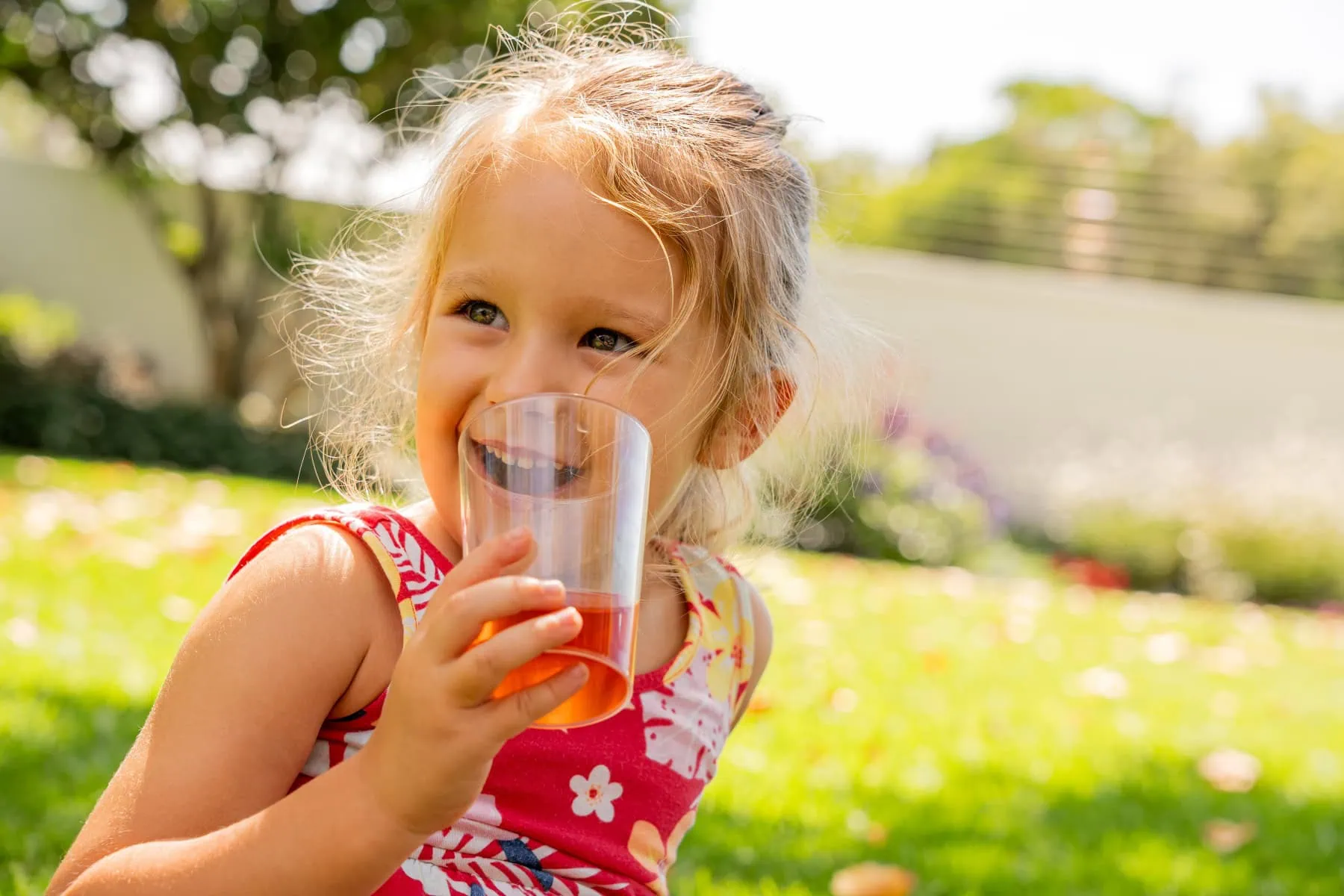 Young girl enjoying Carmién Rooibos tea outdoors, highlighting healthy, child-friendly tea options for parents.
