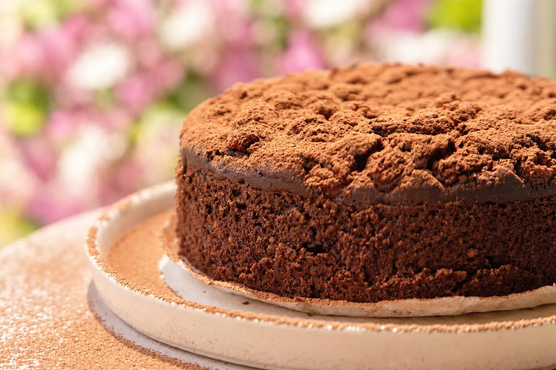 Rich chocolate brownie topped with cocoa powder, perfect for pairing with rooibos tea from Carmién Tea.